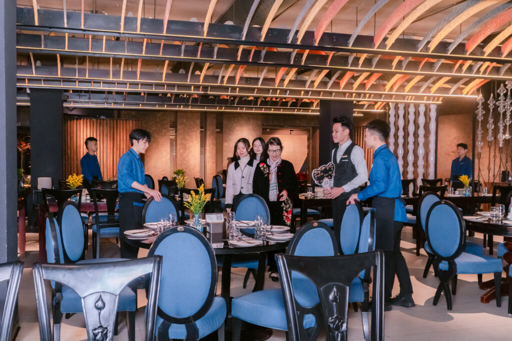 Nhân viên phục vụ bàn hỗ trợ khách hàng tại khu vực bàn ăn